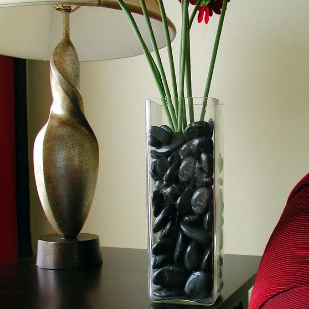 Black Polished Stones in glass vase by lampVase